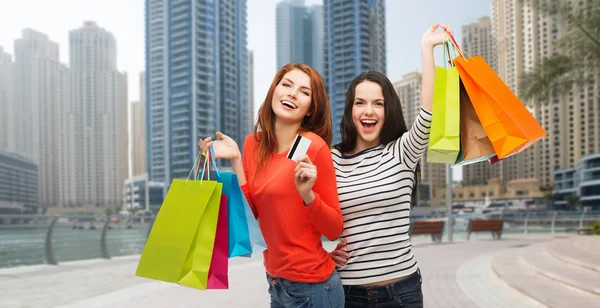 Teenage girls with shopping bags and credit card — Stock Photo, Image