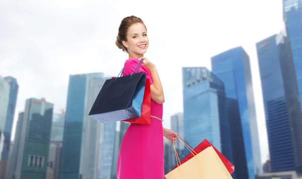 Mujer feliz con bolsas de compras sobre la ciudad de Singapur —  Fotos de Stock