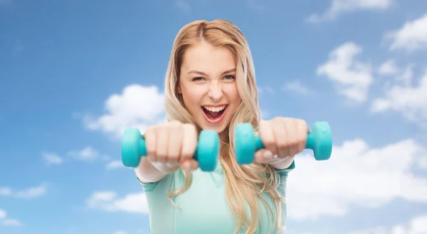 Sorridente bella giovane donna sportiva con manubri — Foto Stock