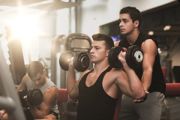 Gruppo di uomini con manubri in palestra — Foto Stock