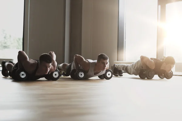 Gruppo di uomini con manubri in palestra — Foto Stock