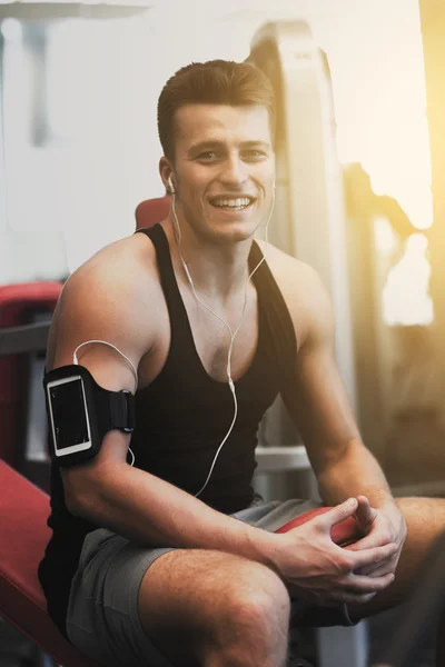 Lachende sportman met smartphone en koptelefoon — Stockfoto