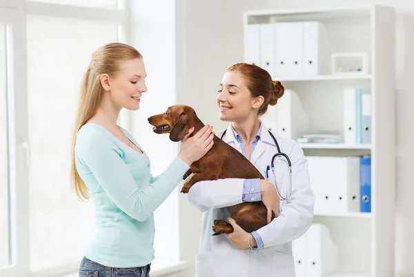 Femme heureuse avec chien et médecin à la clinique vétérinaire — Photo