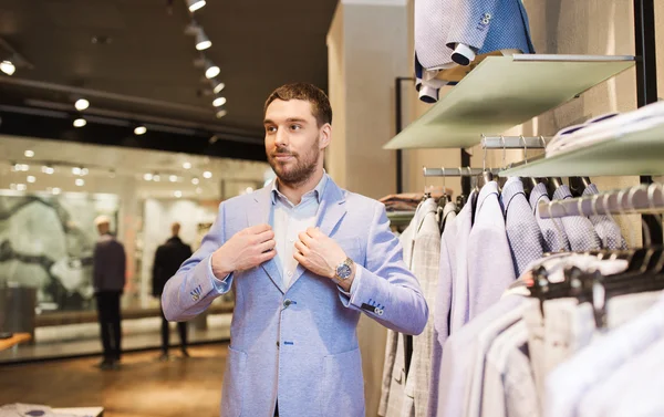 Gelukkig jonge man proberen pak bij kledingwinkel — Stockfoto