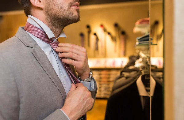 Bliska człowieka wiązanie krawata na odzież sklep lustro — Zdjęcie stockowe