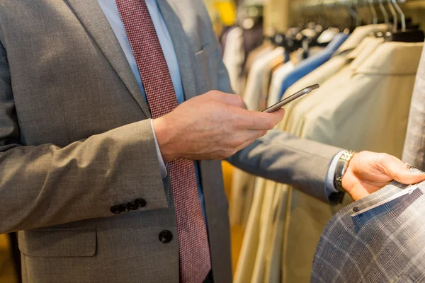 Крупним планом чоловік зі смартфоном в магазині одягу — стокове фото
