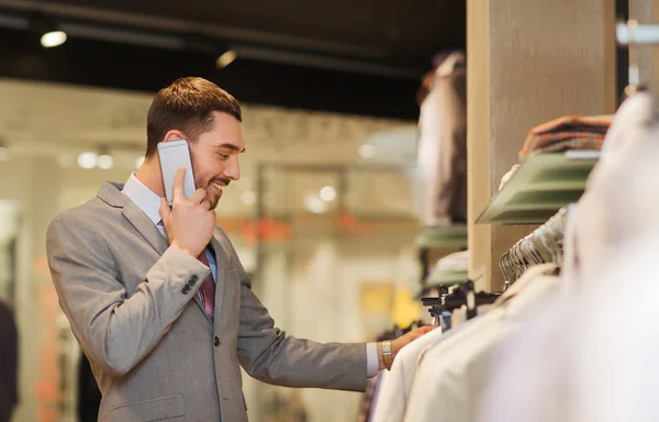 Lycklig man uppmanar smartphone på klädaffär — Stockfoto