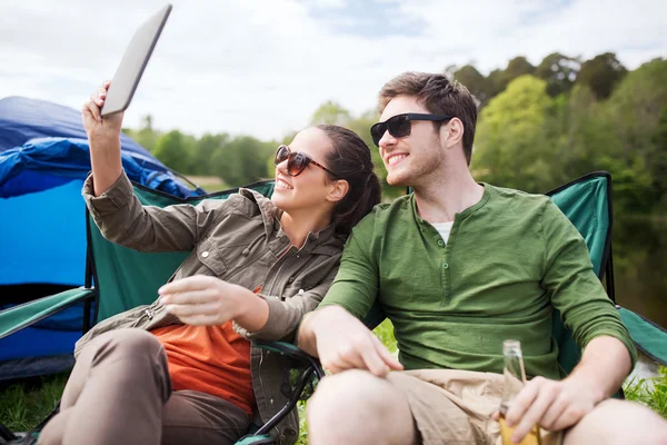 Счастливая пара с планшетным ПК в палатке кемпинга — стоковое фото