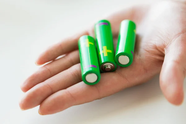 Κοντινό πλάνο της χέρι που κρατά το πράσινο αλκαλικές μπαταρίες — Φωτογραφία Αρχείου