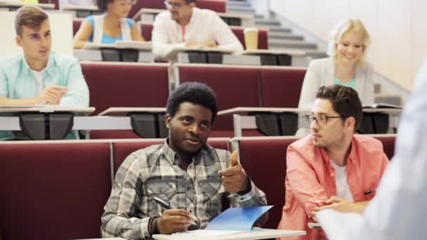 Grupo de estudiantes con cuadernos en la sala de conferencias — Vídeo de stock