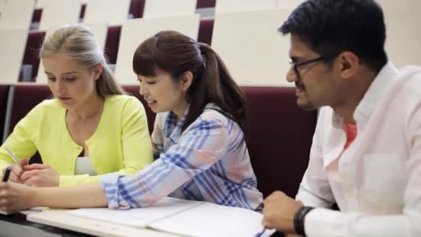 Grupo de estudiantes con cuadernos en la sala de conferencias — Vídeo de stock