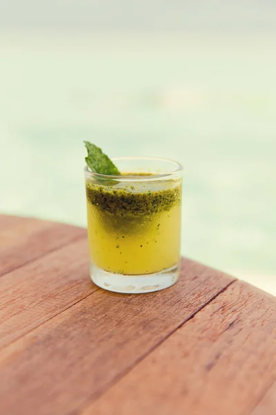 Glas frischer Saft oder Cocktail auf dem Tisch am Strand — Stockfoto