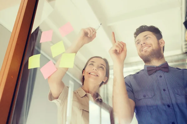 Feliz equipo creativo escribiendo en vidrio de oficina en blanco —  Fotos de Stock