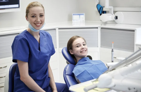 Mutlu kadın dişçi klinikte hasta kızla — Stok fotoğraf