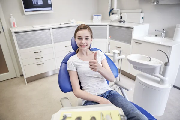 Menina paciente feliz mostrando polegares para cima na clínica — Fotografia de Stock