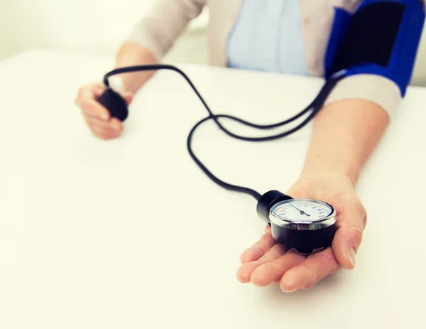 Alte Frau mit Tonometer zur Blutdruckkontrolle — Stockfoto