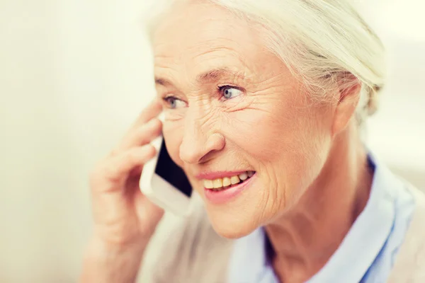 Senior vrouw met smartphone bellen thuis — Stockfoto