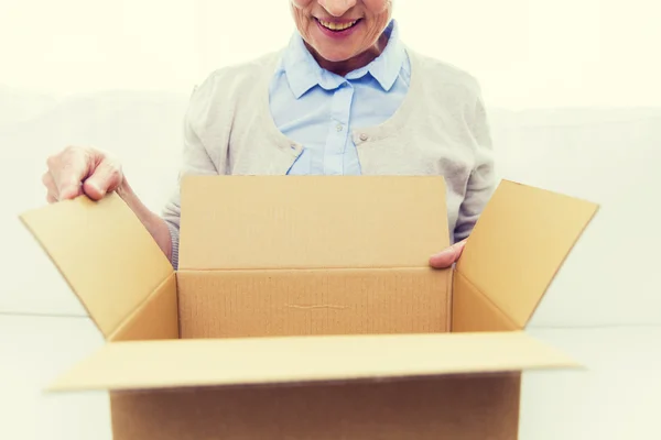 Primer plano de la mujer mayor con caja de paquetes en casa —  Fotos de Stock