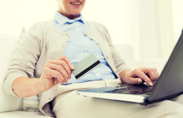 Mujer mayor con laptop y tarjeta de crédito en casa — Foto de Stock