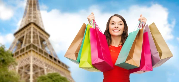 Mujer feliz con bolsas de compras sobre la torre eiffel — Foto de Stock