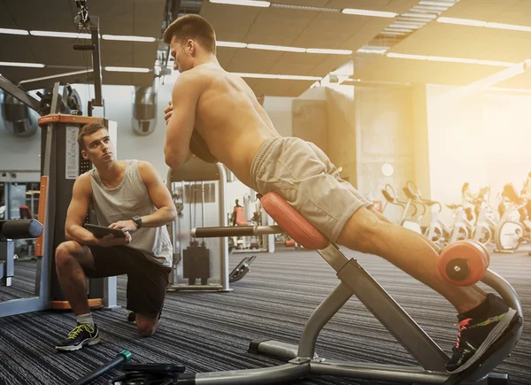 Los hombres que hacen ejercicio en la máquina de gimnasio —  Fotos de Stock