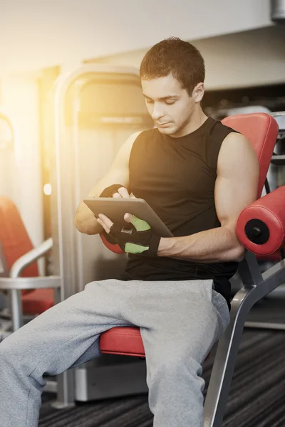 Young man with tablet pc computer in gym — Stock Photo, Image