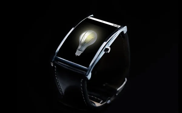 Close up of smart watch with light bulb icon — Stock Photo, Image