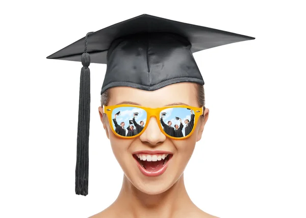 Happy teenage girl in shades and mortarboard hat — Stock Photo, Image