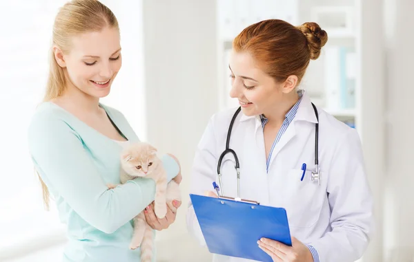 Happy woman with cat and doctor at vet clinic — Stock Photo, Image