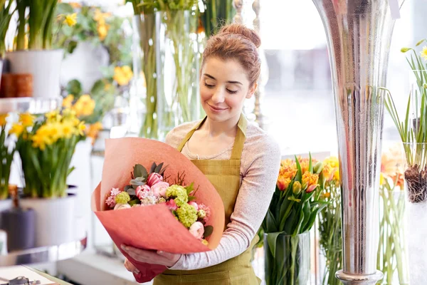 Mulher florista sorridente com cacho na loja de flores — Fotografia de Stock