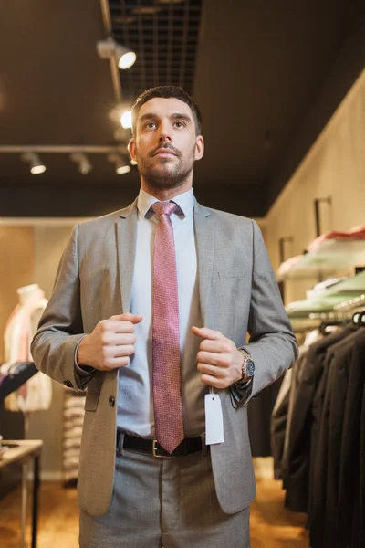 Young man trying suit at clothing store — Stock fotografie