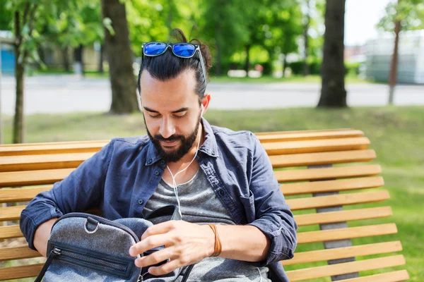 Uomo con zaino e auricolari in città — Foto Stock