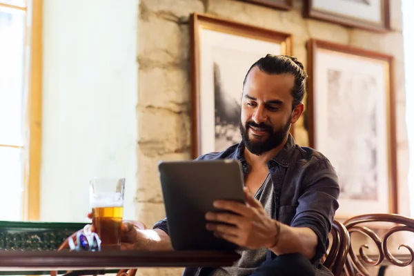 Hombre con la PC tableta beber cerveza en el bar o pub — Foto de Stock