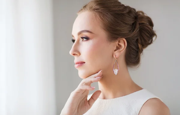 Smiling woman in white dress with pearl jewelry — Stock Photo, Image