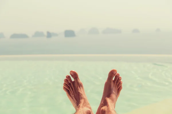 Close-up de pés masculinos sobre o mar e o céu na praia — Fotografia de Stock