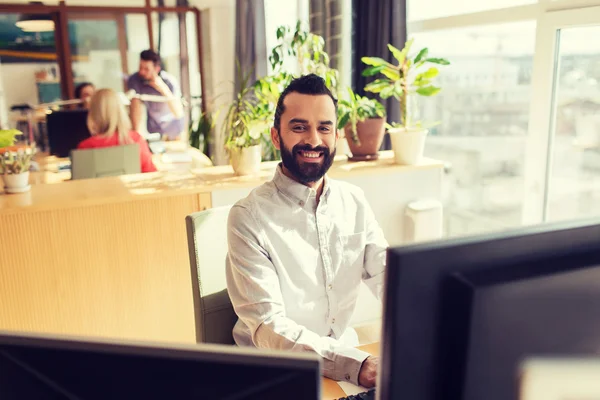 Gelukkig creatieve mannelijke kantoor werknemer met computer — Stockfoto