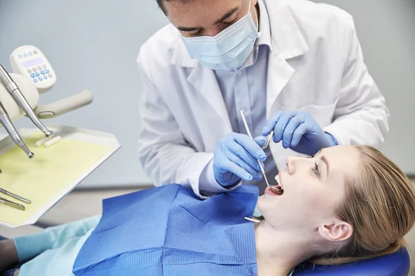 Manliga tandläkare i mask kontroll kvinnliga patientens tänder — Stockfoto