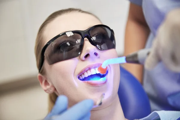 Close up de paciente mulher com luz de cura dental — Fotografia de Stock