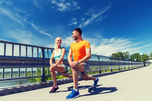 Sonriente pareja estirándose al aire libre —  Fotos de Stock