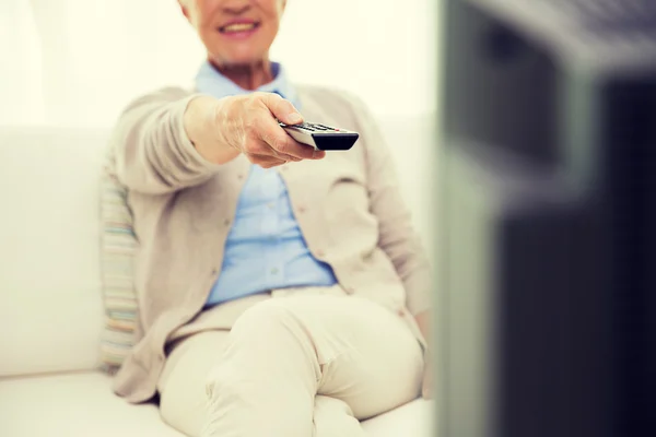 Close up of happy senior woman watching tv at home — Stock Photo, Image