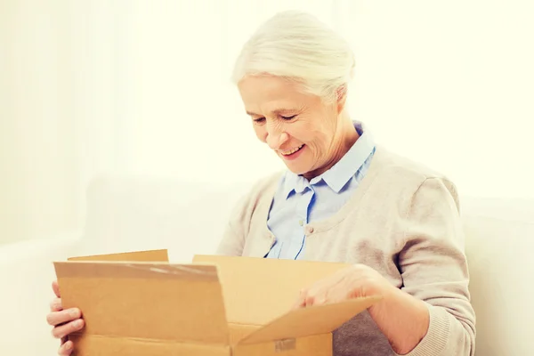 Mujer mayor feliz con caja de paquete en casa —  Fotos de Stock