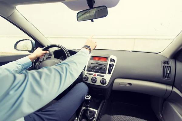 Приближение человека за рулем автомобиля и указание пальца — стоковое фото