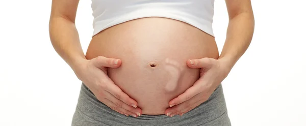 Zblízka těhotné ženy dotýkal její holé bříško — Stock fotografie