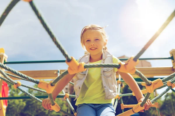 Fröhliches kleines Mädchen klettert auf Kinderspielplatz — Stockfoto