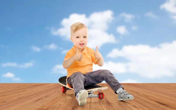 Šťastný chlapeček na skateboard ukazovat palec — Stock fotografie
