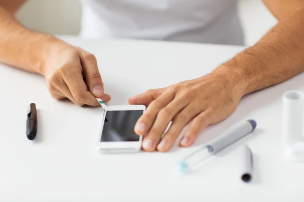 Primer plano del hombre con el teléfono inteligente haciendo análisis de sangre — Foto de Stock