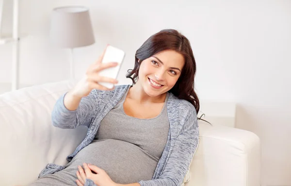 Pregnant woman taking smartphone selfie at home — Stock Photo, Image