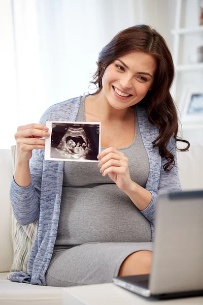 Happy pregnant woman with ultrasound image at home — Stock Photo, Image