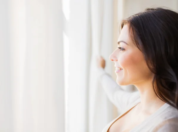 Zbliżenie kobieta patrząc przez okno — Zdjęcie stockowe