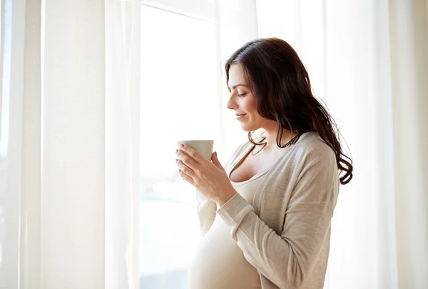 Ευτυχισμένη έγκυος γυναίκα με Κύπελλο πίνοντας τσάι στο σπίτι — Φωτογραφία Αρχείου